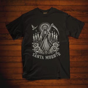 Santa Muerte Gothic Shirt - Holy Death T-Shirt featuring Day of the Dead skull design. Perfect Mexican folk art skeleton top for Dia de los Muertos celebrations or as a unique gift idea. Stylish and symbolic gothic tee for fans of Santa Muerte.