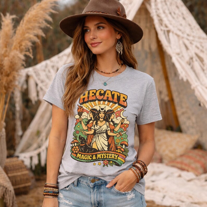 Vintage 70s Hecate retro shirt featuring the Triple Goddess in a mystical boho design, inspired by witchcraft, Wiccan and pagan spirituality. This witchy graphic tee shows Hekate with moon phases and occult symbols, perfect for spiritual women, witches, and lovers of magic. Ideal witchy gift for Wiccan, pagan and boho aesthetic fans.