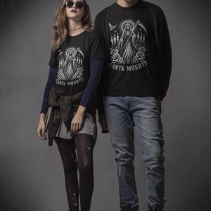 Santa Muerte Gothic Shirt - Holy Death T-Shirt featuring Day of the Dead skull design. Perfect Mexican folk art skeleton top for Dia de los Muertos celebrations or as a unique gift idea. Stylish and symbolic gothic tee for fans of Santa Muerte.