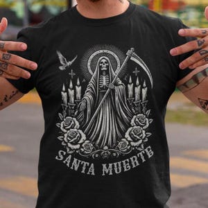 Santa Muerte Gothic Shirt - Holy Death T-Shirt featuring Day of the Dead skull design. Perfect Mexican folk art skeleton top for Dia de los Muertos celebrations or as a unique gift idea. Stylish and symbolic gothic tee for fans of Santa Muerte.