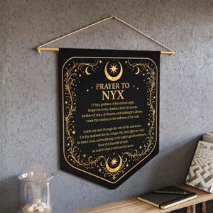 May include: A black banner with gold detailing, displaying the text "PRAYER TO NYX". The design includes crescent moons, stars, and a central starburst. The text is a prayer to Nyx, the goddess of the night.