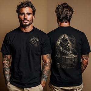 May include: A black short-sleeve t-shirt featuring a small circular graphic on the front chest with the text "EXECUTIONER" and a detailed illustration on the back depicting a hooded figure with a sword standing over a wooden chopping block.