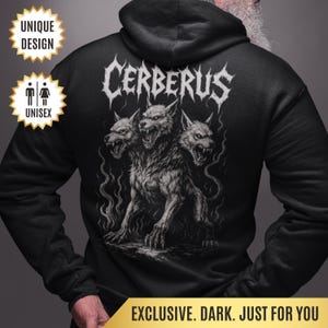 May include: Black unisex hoodie featuring a detailed illustration of Cerberus, the three-headed dog from Greek mythology. The word "CERBERUS" is printed above the illustration in a gothic font. The hoodie has a unique design and is exclusive.