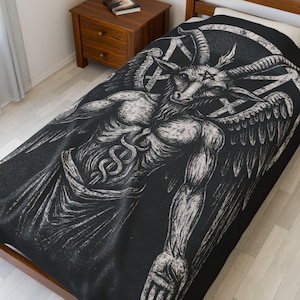 May include: Black and white graphic of a horned figure with wings, a pentagram, and a caduceus symbol on a black blanket. The blanket is on a wooden bed frame. The artwork is detailed and appears to be a print.