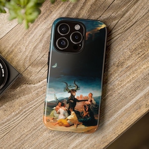 May include: A black iPhone case with a painting of a dark scene with a goat and people. The case has a black background and a moon in the upper left corner.