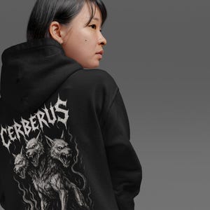 Cerberus Hoodie featuring a three-headed hellhound design inspired by Greek mythology. Gothic sweatshirt perfect for metalheads. Hades guardian graphic, ideal heavy metal gift for fans of dark fantasy and mythology