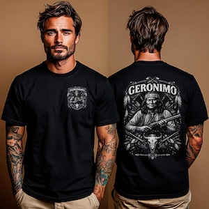 Op de afbeelding: Zwart T-shirt met een afbeelding van Geronimo op de voor- en achterkant. De afbeelding op de voorkant is een kleinere versie van het ontwerp op de achterkant. De afbeelding op de achterkant bevat het woord "GERONIMO" boven een portret van Geronimo met een geweer.