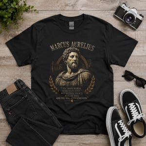 Marcus Aurelius shirt featuring a vintage-inspired portrait of the Roman emperor and famous Stoic philosopher. This stoicism tee is perfect for philosophy lovers, history enthusiasts, self-discipline seekers, and fans of ancient Rome. Motivational philosophy shirt inspired by Stoic wisdom, resilience, virtue, personal growth, and the teachings of Marcus Aurelius.