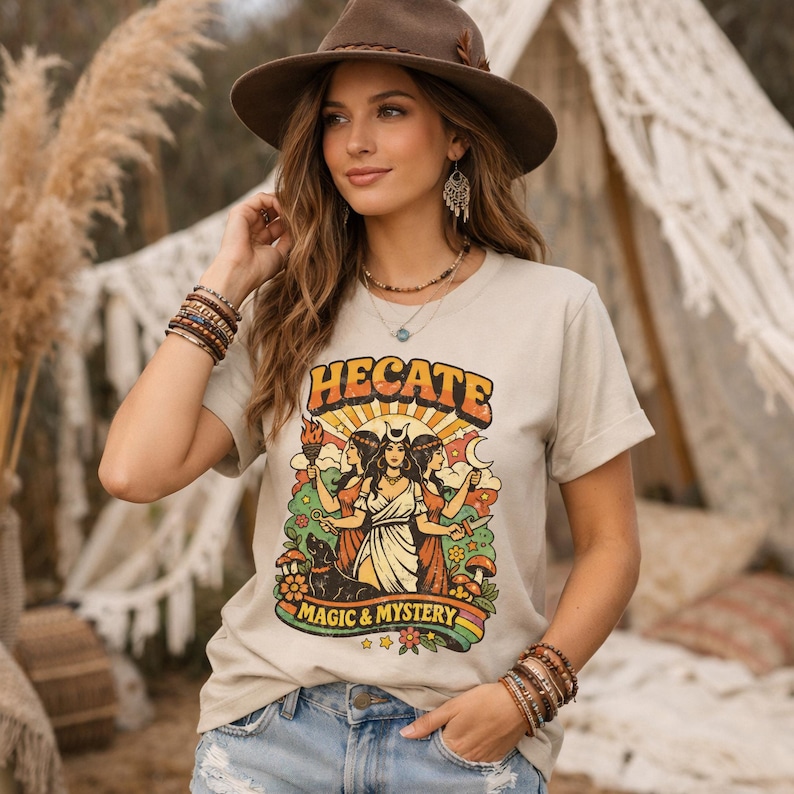Vintage 70s Hecate retro shirt featuring the Triple Goddess in a mystical boho design, inspired by witchcraft, Wiccan and pagan spirituality. This witchy graphic tee shows Hekate with moon phases and occult symbols, perfect for spiritual women, witches, and lovers of magic. Ideal witchy gift for Wiccan, pagan and boho aesthetic fans.