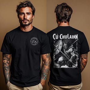 Może przedstawiać: Czarny t-shirt z krótkim rękawem, posiadający małą okrągłą grafikę na lewej piersi oraz dużą prostokątną grafikę na plecach. Oba nadruki przedstawiają wojownika z włócznią i tarczą, z napisem Cú Chulainn umieszczonym na tylnej części.