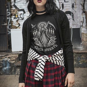 Santa Muerte Gothic Shirt - Holy Death T-Shirt featuring Day of the Dead skull design. Perfect Mexican folk art skeleton top for Dia de los Muertos celebrations or as a unique gift idea. Stylish and symbolic gothic tee for fans of Santa Muerte.
