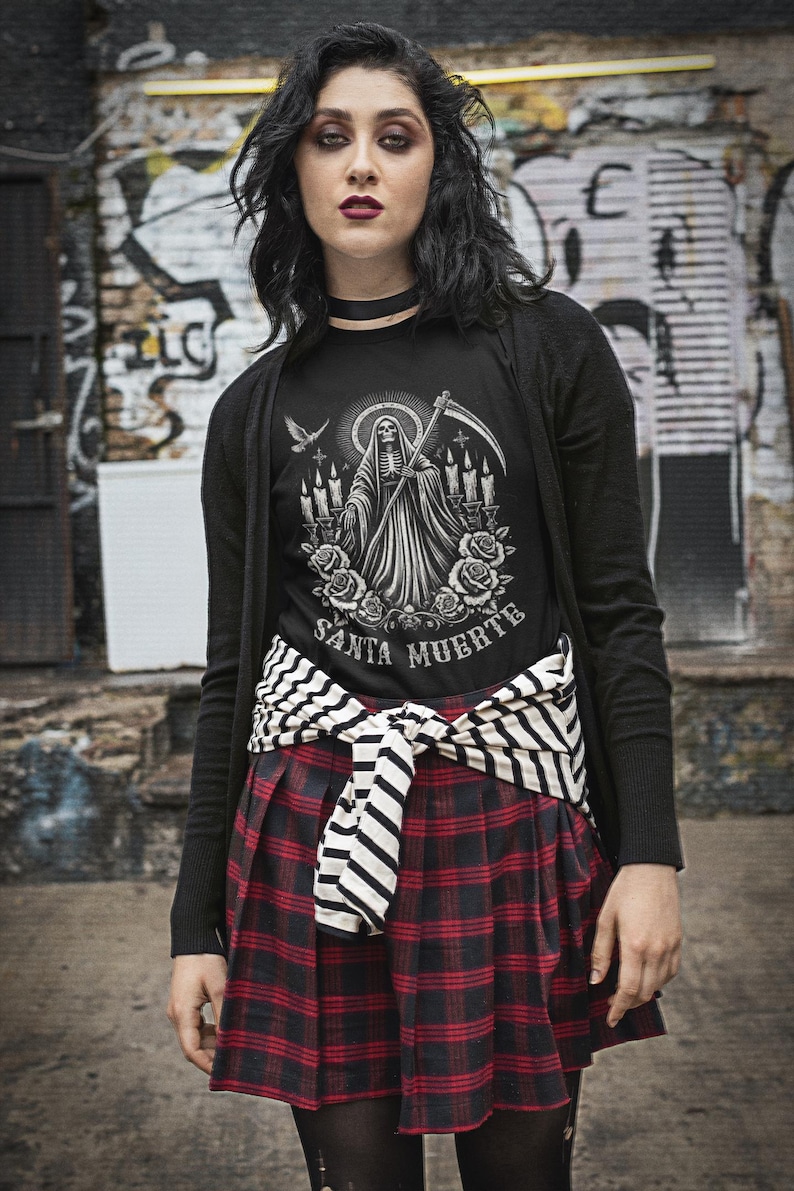 Santa Muerte Gothic Shirt - Holy Death T-Shirt featuring Day of the Dead skull design. Perfect Mexican folk art skeleton top for Dia de los Muertos celebrations or as a unique gift idea. Stylish and symbolic gothic tee for fans of Santa Muerte.