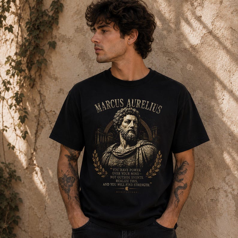 Marcus Aurelius shirt featuring a vintage-inspired portrait of the Roman emperor and famous Stoic philosopher. This stoicism tee is perfect for philosophy lovers, history enthusiasts, self-discipline seekers, and fans of ancient Rome. Motivational philosophy shirt inspired by Stoic wisdom, resilience, virtue, personal growth, and the teachings of Marcus Aurelius.