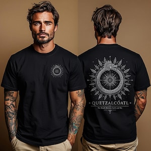 Op de afbeelding: Een zwart t-shirt met korte mouwen voorzien van een kleine cirkelvormige Quetzalcoatl-afbeelding op de borst en een groot, gedetailleerd cirkelvormig ontwerp op de rug. De achterkant toont een gevederde slang, een kompasachtig centrum en de tekst QUETZALCÓATL.