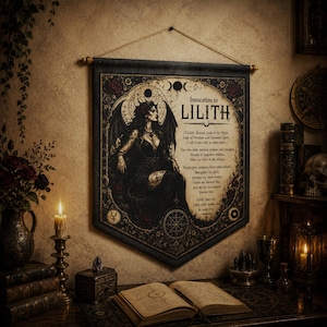 May include: A black fabric wall hanging featuring a central illustration of a winged figure in a dark gown, surrounded by celestial symbols and the text Invocation to LILITH, with a printed prayer, suspended from a wooden rod with a rope hanger.