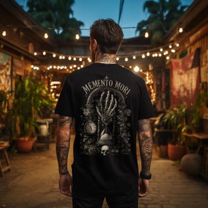 Memento Mori shirt featuring a vintage skeleton hand holding an hourglass, inspired by Stoic philosophy and mortality symbolism. Gothic t-shirt design with dark academia aesthetic, antique engraving style artwork, and memento mori theme. Perfect for lovers of stoicism, philosophy, gothic fashion, medieval art, existential symbolism, and alternative clothing.
