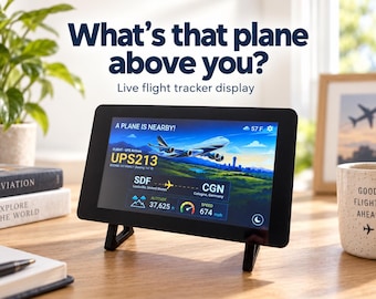 Può includere: Un display digitale nero per il tracciamento dei voli in tempo reale su supporto che mostra un aereo UPS 747-8, volo UPS213, da Louisville a Colonia, altitudine 37.625 ft, velocità 674 mph, con il testo What's that plane above you? Live flight tracker display.