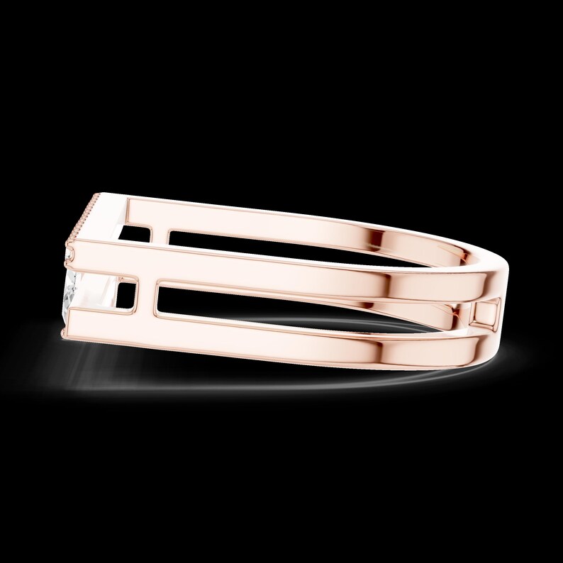 May include: Rose gold ring with a rectangular gemstone and a unique double-band design. The ring features a minimalist style with a polished finish, showcasing a modern and elegant aesthetic. The gemstone is set in a bezel setting.