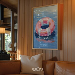 Digital painting of a pink and white lifebuoy floating on calm blue water. Bright and playful coastal art with summery, nautical vibes.