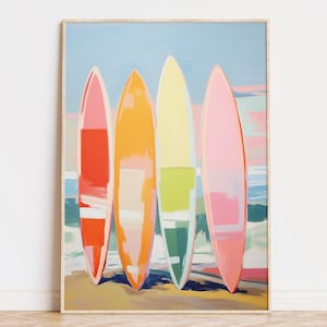 Digital wall art of four colorful surfboards in shades of coral, orange, yellow, and pink standing on a beach — perfect printable art for coastal or summer home decor.