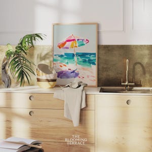 Bright watercolor-style painting of a colorful beach umbrella by the ocean — vibrant coastal wall art printable for summer home decor.