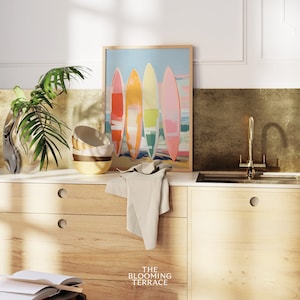 Digital wall art of four colorful surfboards in shades of coral, orange, yellow, and pink standing on a beach — perfect printable art for coastal or summer home decor.