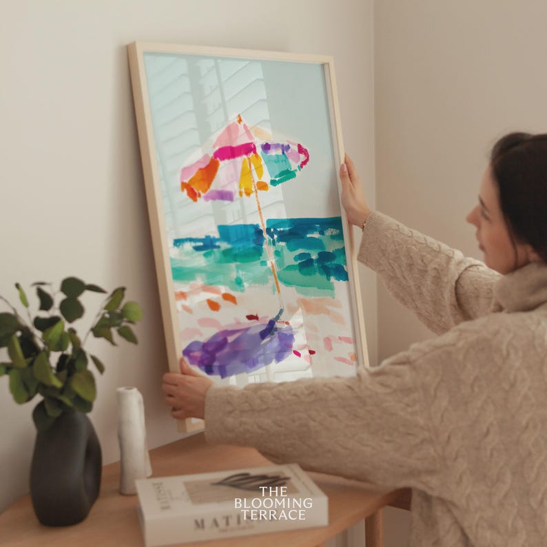 Bright watercolor-style painting of a colorful beach umbrella by the ocean — vibrant coastal wall art printable for summer home decor.