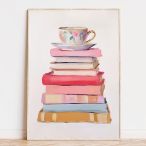 Puede incluir: Una pila de libros coloridos con una taza de té floral y un platillo en la parte superior. Los libros son en tonos de rosa, rojo, azul y amarillo.
