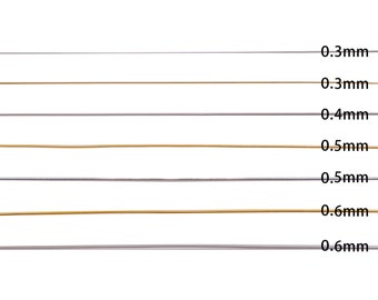 May include: A close-up of seven different sizes of silver and gold wire. The wire sizes are labeled 0.3mm, 0.3mm, 0.4mm, 0.5mm, 0.5mm, 0.6mm, and 0.6mm.