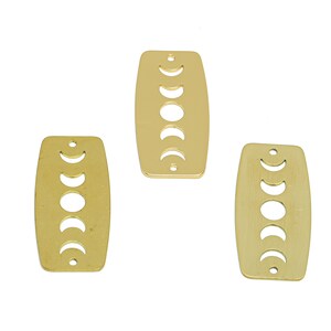 May include: Three gold metal rectangular charms with a crescent moon design. Each charm has five crescent moons in a vertical row.