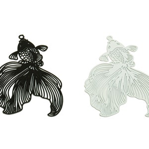 Puede incluir: Dos abalorios de metal en forma de pez dorado, uno negro y otro verde claro, con intrincados diseños recortados. Los abalorios son perfectos para la elaboración de joyas o el scrapbooking.