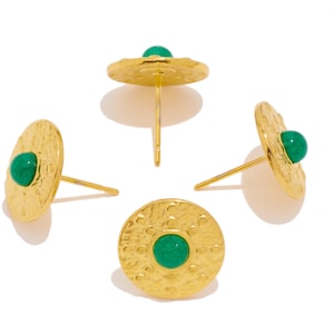 May include: Four gold stud earrings with green gemstone accents. Each earring features a round, textured disc with a small, round green stone in the centre.
