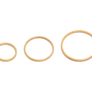 以下が含まれることがあります： 異なるサイズの3つの金色メタルリング。リングはシンプルでミニマルなデザインです。