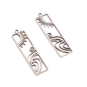 May include: Two silver-colored rectangular pendants. Each pendant features a cut-out design of a sun and ocean waves. The pendants have a small loop at the top for attaching to a chain or other jewelry component.