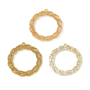 May include: Three gold metal circle frames with a leaf design. The frames are about 2 inches in diameter.