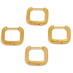 May include: Four gold square hoop earrings. The earrings are simple and minimalist in design.
