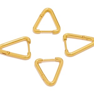 Puede incluir: Cuatro pendientes de aro triangulares de oro. Los pendientes son de diseño simple y moderno.