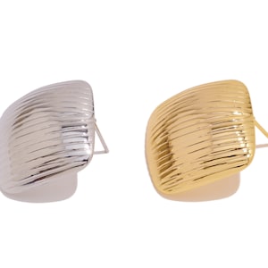 May include: A pair of earrings, one silver and one gold, with a textured, ribbed design.