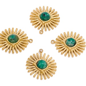May include: Four gold sunburst charms with green gemstone centres. Each charm has a loop for attaching to jewellery.