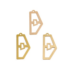 Könnte beinhalten: Drei goldfarbene geometrische Anhänger mit einem Ausschnitt-Design. Jeder Anhänger hat eine rechteckige Form mit einem einzigartigen Innenausschnitt und einer kleinen Schlaufe oben zur Befestigung an Schmuck. Die Anhänger werden vor weißem Hintergrund gezeigt.