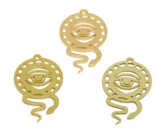 May include: Three gold-colored metal charms featuring an eye with a snake design. Each charm has a circular cutout with an eye design and a snake tail extending from the bottom.