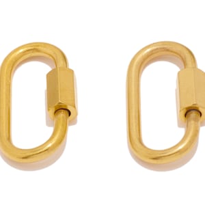 May include: Two gold-toned metal clasps, each with a hexagonal barrel in the center.