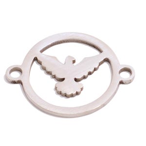 May include: Silver-toned metal charm featuring a cutout design of a dove in flight inside a circle. The charm has two small loops on the side for attaching to a bracelet or necklace.