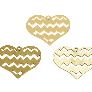 Puede incluir: Tres dijes de metal dorado en forma de corazón con un patrón de chevron. Los dijes tienen un agujero en la parte superior para colgar.