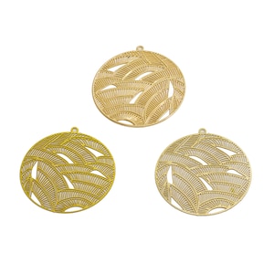 Peut inclure: Trois breloques en métal de couleur dorée avec un design circulaire présentant un motif découpé de feuilles qui se chevauchent.