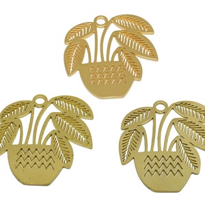 May include: Three gold metal plant pot charms with a cutout design. Each charm features a pot with three leaves and a decorative pattern.