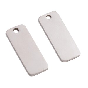 May include: Two silver rectangular metal tags with a hole at the top for hanging.