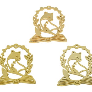 Pode incluir: Tr&ecirc;s pingentes de metal dourado com uma raposa enroscada em um livro com uma coroa de folhas ao redor.