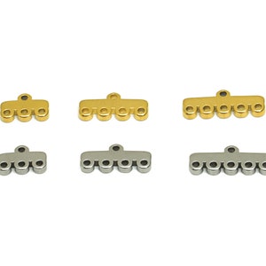May include: Six metal connector charms, three gold and three silver, each with five holes. The charms are designed to connect multiple strands of beads or other jewelry components.