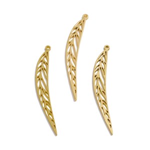 May include: Three gold leaf-shaped metal charms with a delicate cutout design. The charms are perfect for jewelry making or crafting.